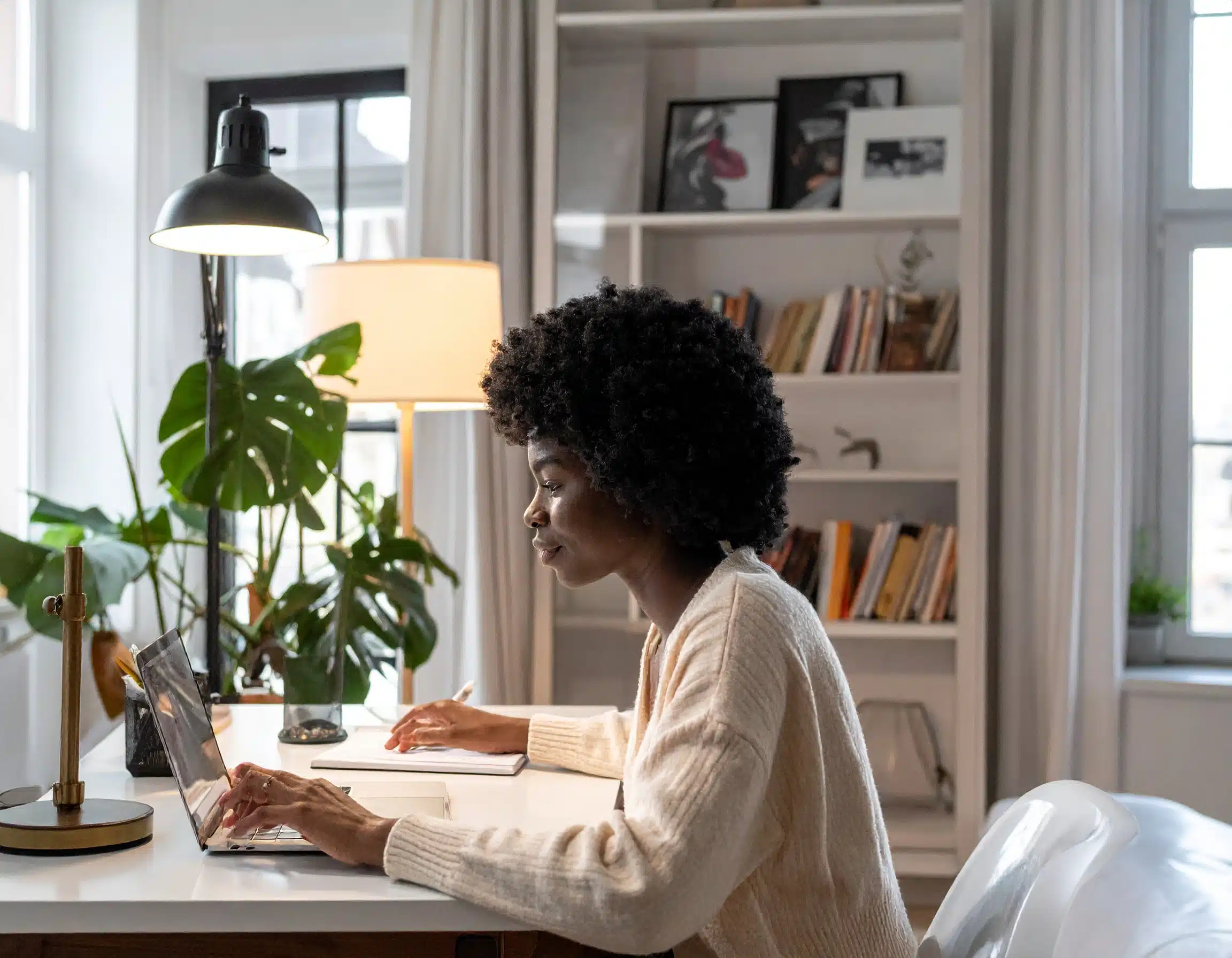 a woman sitting at a desk working on a laptop